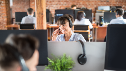 A lady in a call center with a headset on.